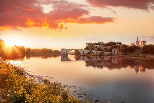 Sonnenuntergang über der historischen Brücke Pont Saint-Bénézet und der Stadt Avignon am Fluss Rhône