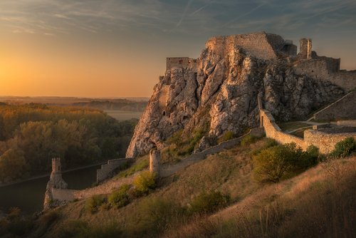 View of Theben Castle in Bratislava, surrounded by rocks and expansive landscape at sunset.