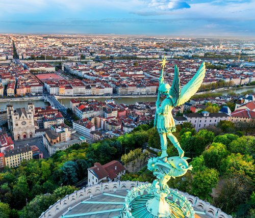 Panorama von Lyon mit der Rhône und der Basilika Notre-Dame de Fourvière im Vordergrund und dem Stadtzentrum im Hintergrund